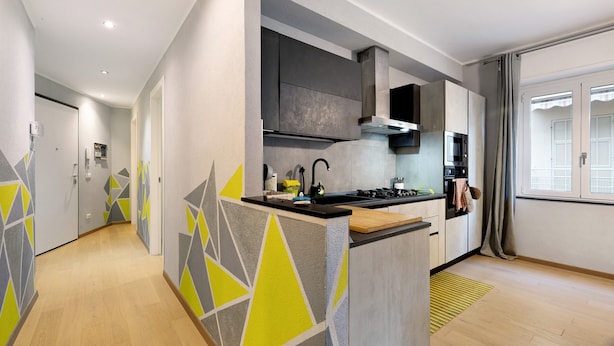 Een moderne keuken met een centraal eiland, inbouwapparatuur en uitzicht op buiten.