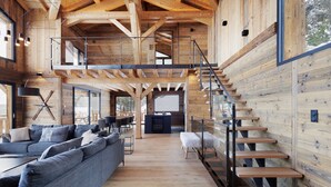 Un intérieur spacieux avec un escalier en bois, un grand canapé et un coin repas.