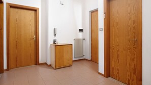 Ein Korridor mit Holztüren, einem Heizkörper und einem kleinen Holzschrank.