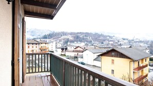 Un balcon avec vue sur la ville et les montagnes.