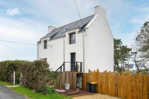 A two-story house with a wooden fence, a small balcony, and a gravel driveway. - Holiday Home 'Villa Trevi ,200m Plage, Vue Mer' with Sea View (TREGUNC)