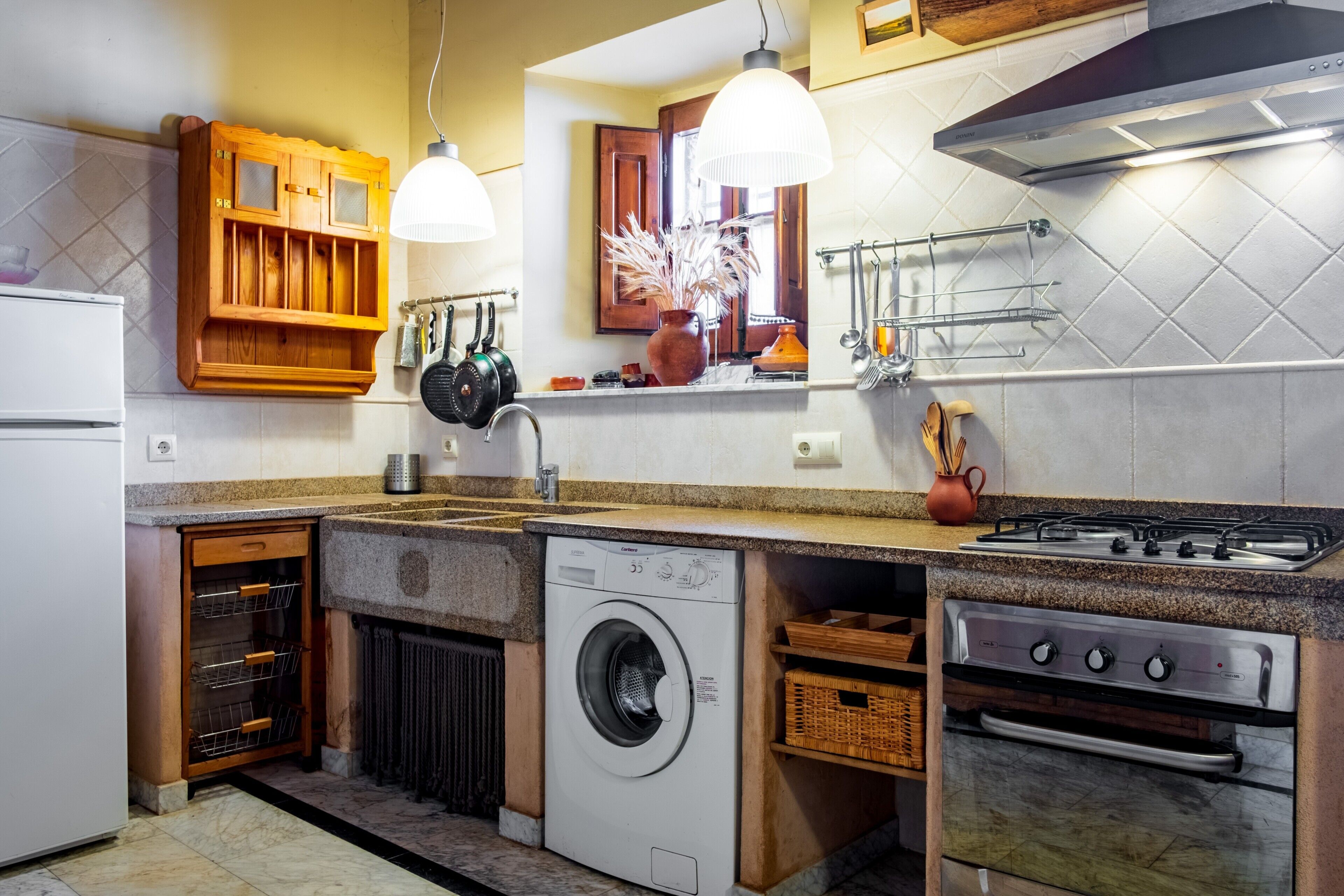 A kitchen with a built-in washer, oven, and gas stove.