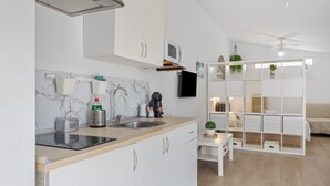 A modern kitchen with white cabinets, a black countertop, and a built-in microwave.