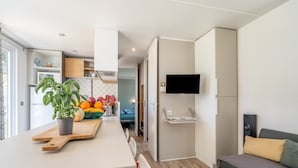 Una cocina moderna con encimera de madera, una planta en maceta y un frutero.