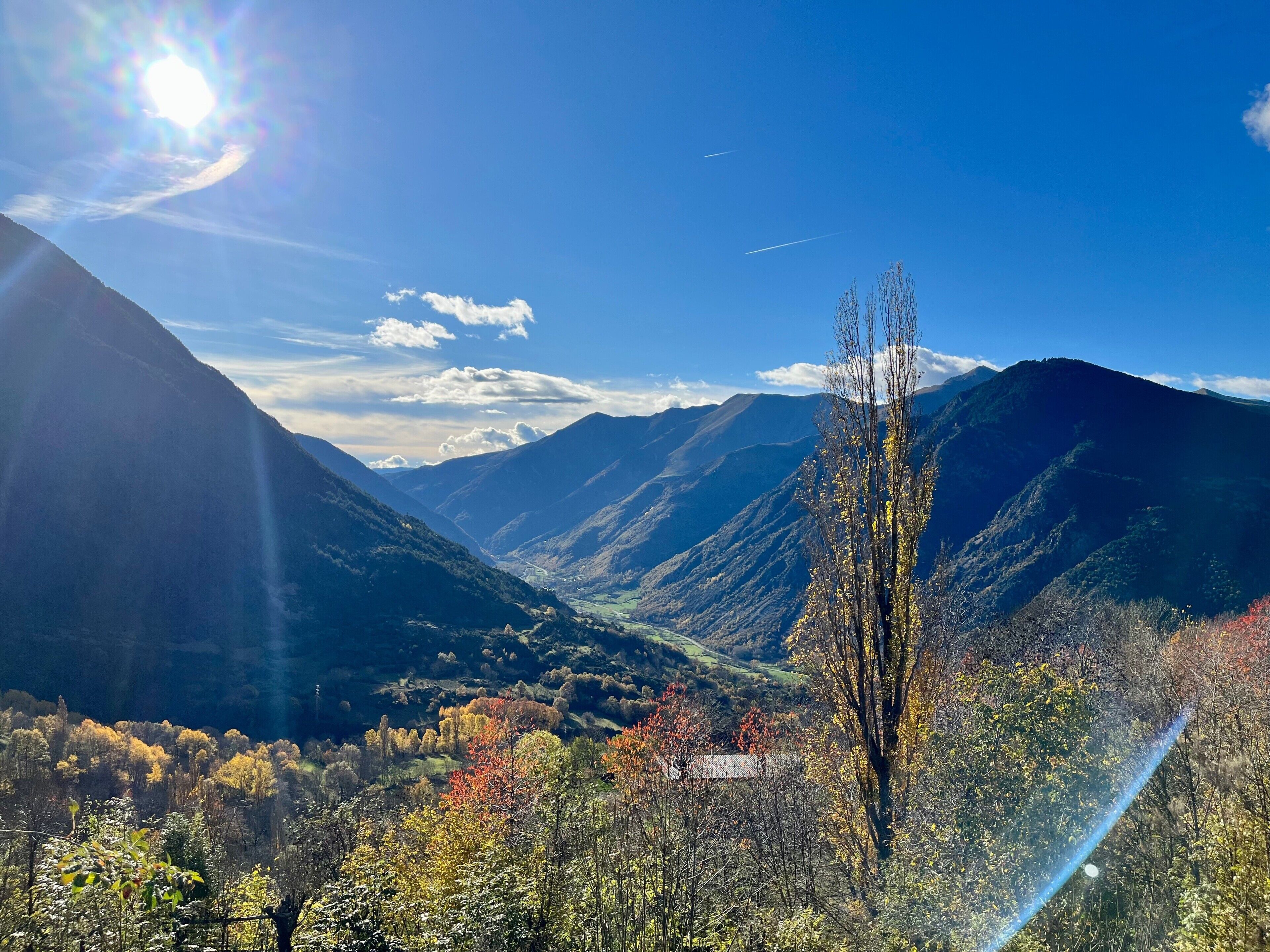 Un paisaje montañoso con un valle y cielo despejado.