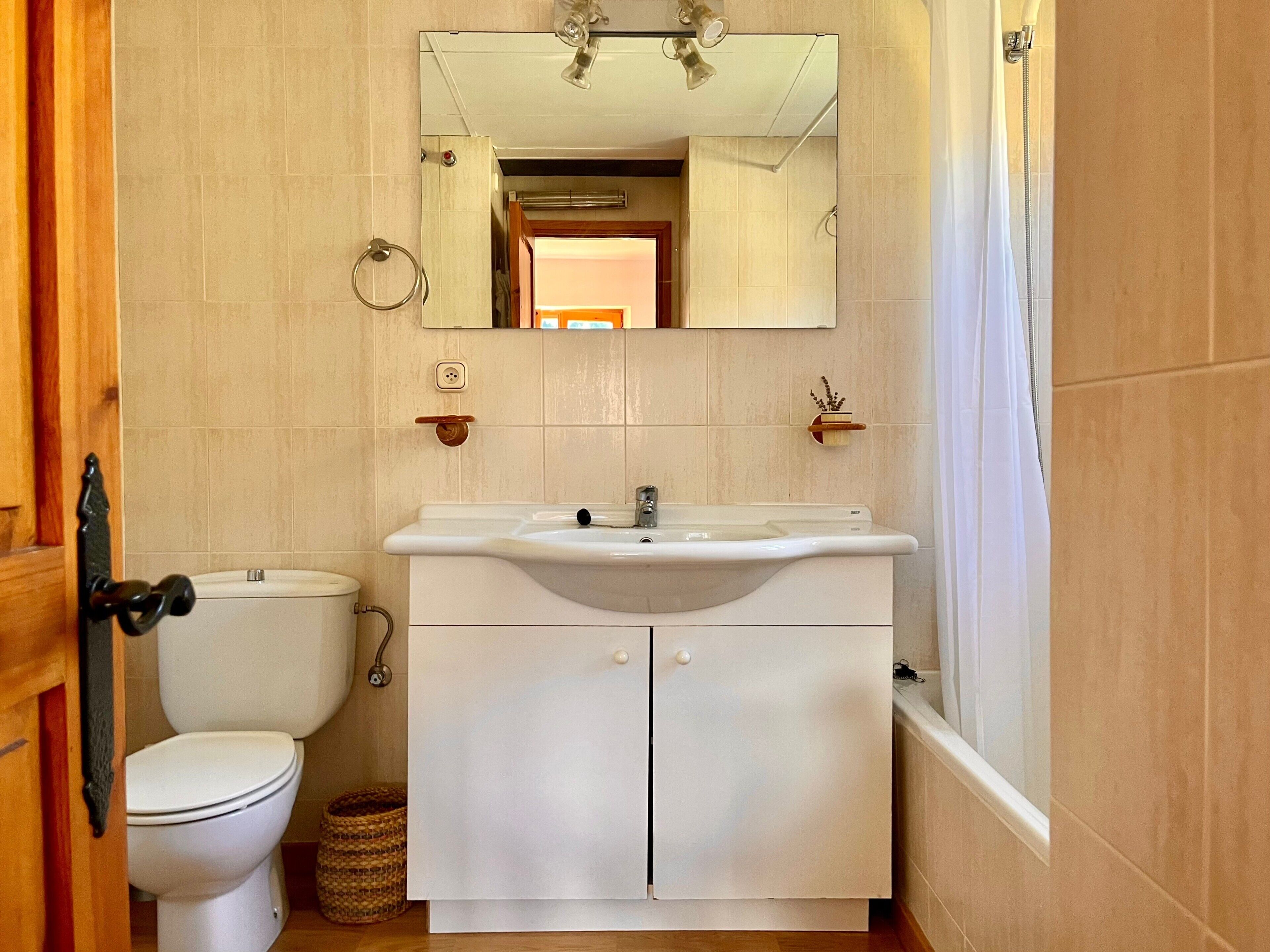Un baño con inodoro, lavamanos y ducha.