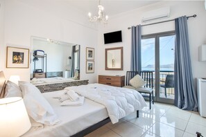 A hotel room with a bed, a chair, a TV, a mirror, and a balcony with curtains. - Room 'Porto Chania B2' with Shared Garden, Wi-Fi and Air Conditioning (Chania Town)