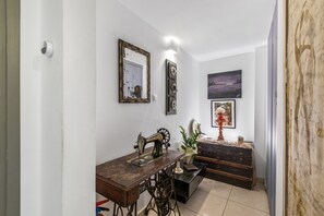 A room with a sewing machine, a dresser, and wall-mounted artwork. - Room 'Porto Chania B2' with Shared Garden, Wi-Fi and Air Conditioning (Chania Town)