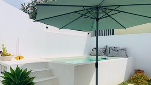 A hot tub with steps leading up to it, a green umbrella, and potted plants. - Tiny Home 'Casa Das Cantonas Valada' with Shared Pool, Wi-Fi and Air Conditioning (Valada)