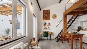 A modern interior with a wooden staircase, a dining area, and a cozy seating space. - Tiny Home 'Casa Das Cantonas Valada' with Shared Pool, Wi-Fi and Air Conditioning (Valada)