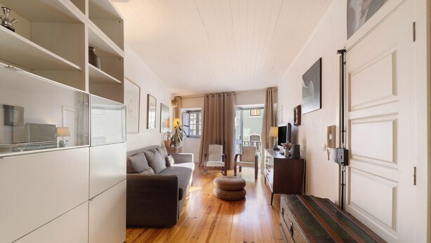 A spacious living area with a sofa, ottoman, and a wooden bench.