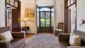 A room with two sofas, a rug, a lamp, a chair, and a door leading to a balcony. - Holiday Home 'Solar Da Tirosa' with Private Pool, Private Terrace and Wi-Fi (Boliqueime)