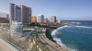 Paisatge urbà costaner amb edificis alts, una platja i un cel serè.