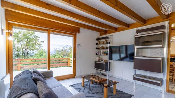 Un salon moderne comprenant un canapé, une table basse, un téléviseur et une bibliothèque.