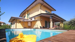 Una casa de dos pisos con piscina delantera.
