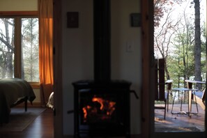 A room with a fireplace, a bed, and a view of the outdoors.