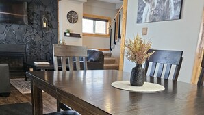 A dining area with a long table, benches, and a vase with dried plants. - Home on Grand Lake, in Saginaw, Near Ivy Black (Saginaw)
