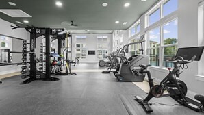 Une salle de sport équipée de matériel de musculation, de tapis de course et d’un vélo d’exercice.