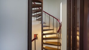Una escalera de caracol con barandilla roja y escalones de madera.