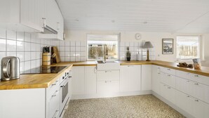 A modern kitchen with white cabinetry, a wooden countertop, a built-in oven, and a window providing natural light. - Beautiful home in ølsted with WiFi (Ølsted)