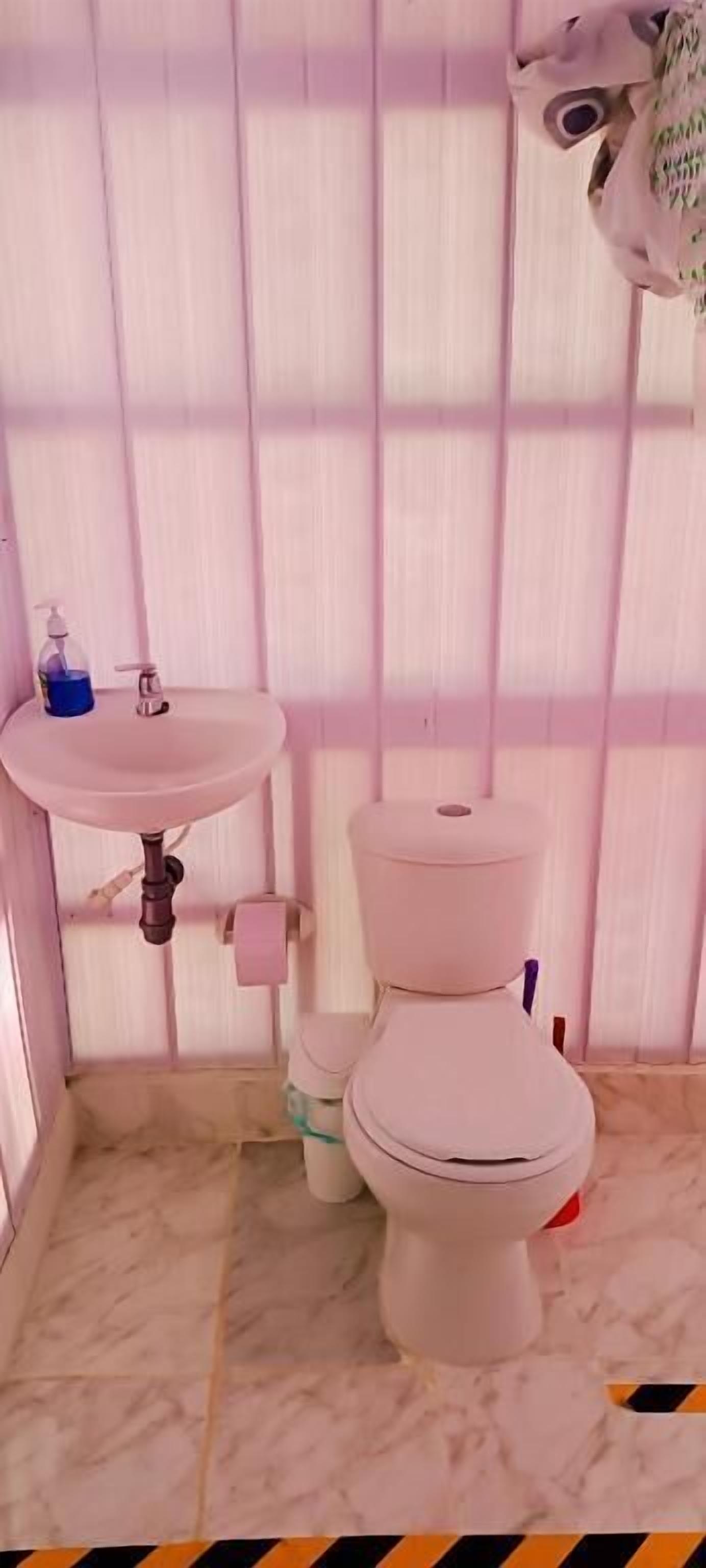 A bathroom with a white sink, toilet, and marble floor.