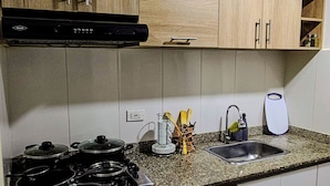 A kitchen with wooden cabinets, a stove, a sink, and a coffee maker. - Smart apartment in exclusive area  (Popayán)