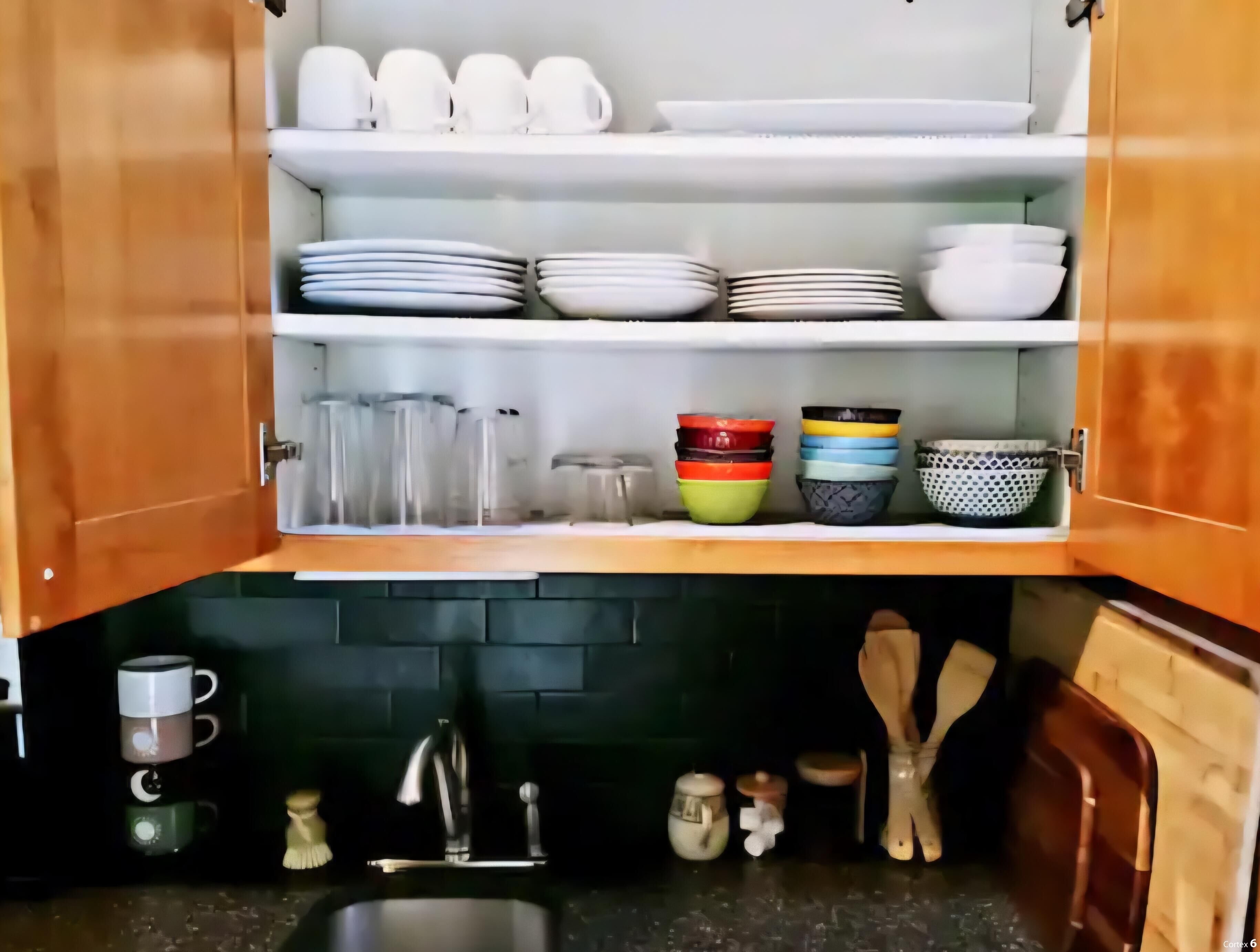 A kitchen with wooden cabinets, a sink, and various kitchen utensils.