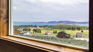 Vista desde una ventana con vistas a una zona residencial, casas, un campo de golf y montañas a lo lejos.