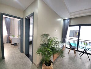A modern hotel room with a balcony, a dining area, and a large potted plant. - My Natural Villas by You Long (Siem Reap)