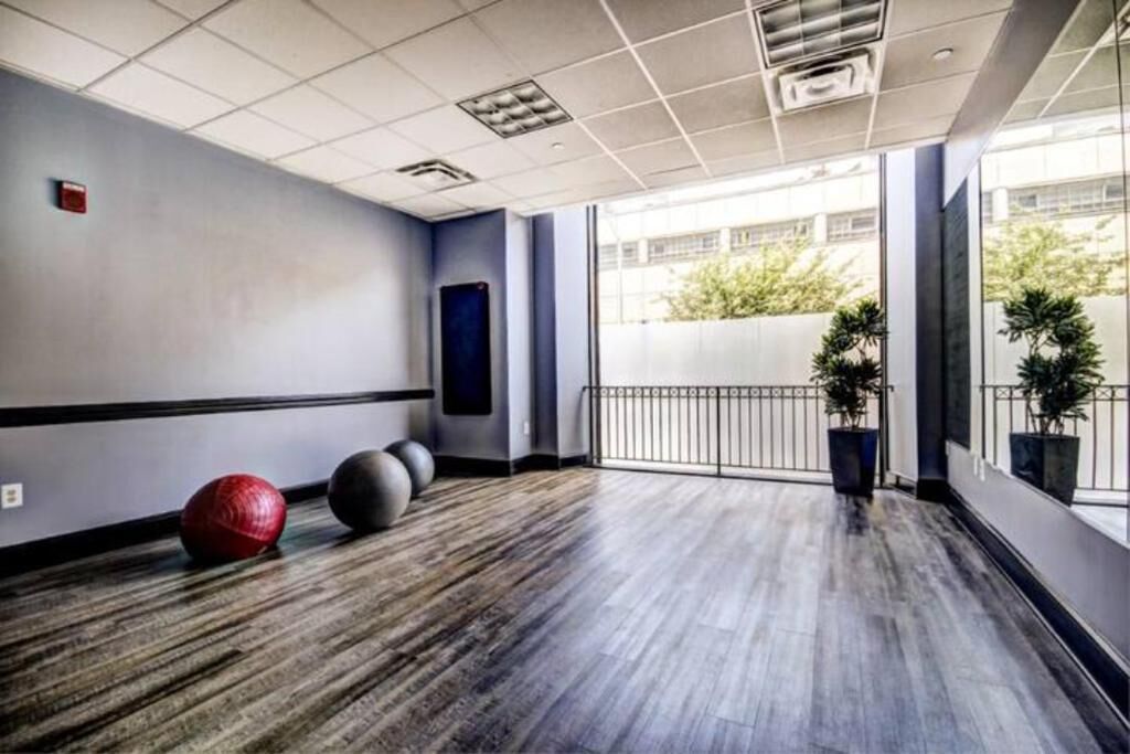 Une chambre d’hôtel avec une grande fenêtre, un plancher en bois et des ballons d’exercice.