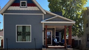 A two-story house with a covered porch and a small front yard. - Come enjoy the Victorian charm of this beautiful home. (La Junta)