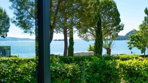 A view of a lake with trees and a boat in the foreground.