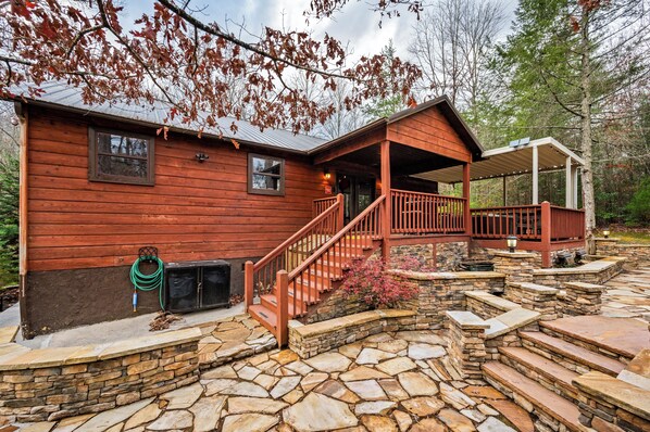 A wooden cabin with a stone staircase leading to a porch. - Oasis Escape- Hot Tub, Waterfalls & Cozy Nights (Pigeon Forge)