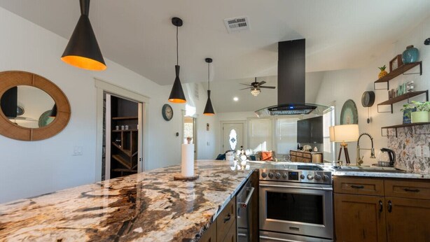A modern kitchen with granite countertops, stainless steel appliances, and pendant lighting. - Kendall Whittier TU, Downtown (Tulsa)