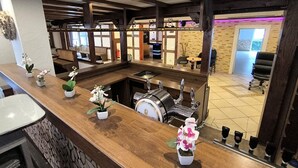 A bar area with a counter, potted plants, and a beer tap. - Comfortable and versatile room -perfect for relaxation, work and exchange (Winterberg)