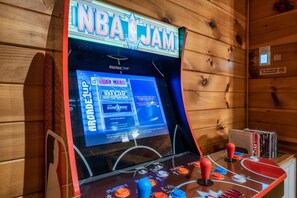 Une borne d’arcade arborant le logo « NBA JAM », un écran affichant les options du jeu et des commandes à l’aide d’un joystick.