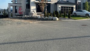 A modern two-story house with a garage, a driveway, and a car parked in the driveway. - Luxury Suite situated on top of mountain in a prestigious location. (Abbotsford)