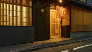 Un edificio japonés tradicional con fachada de madera, una puerta corrediza y una entrada pequeña.