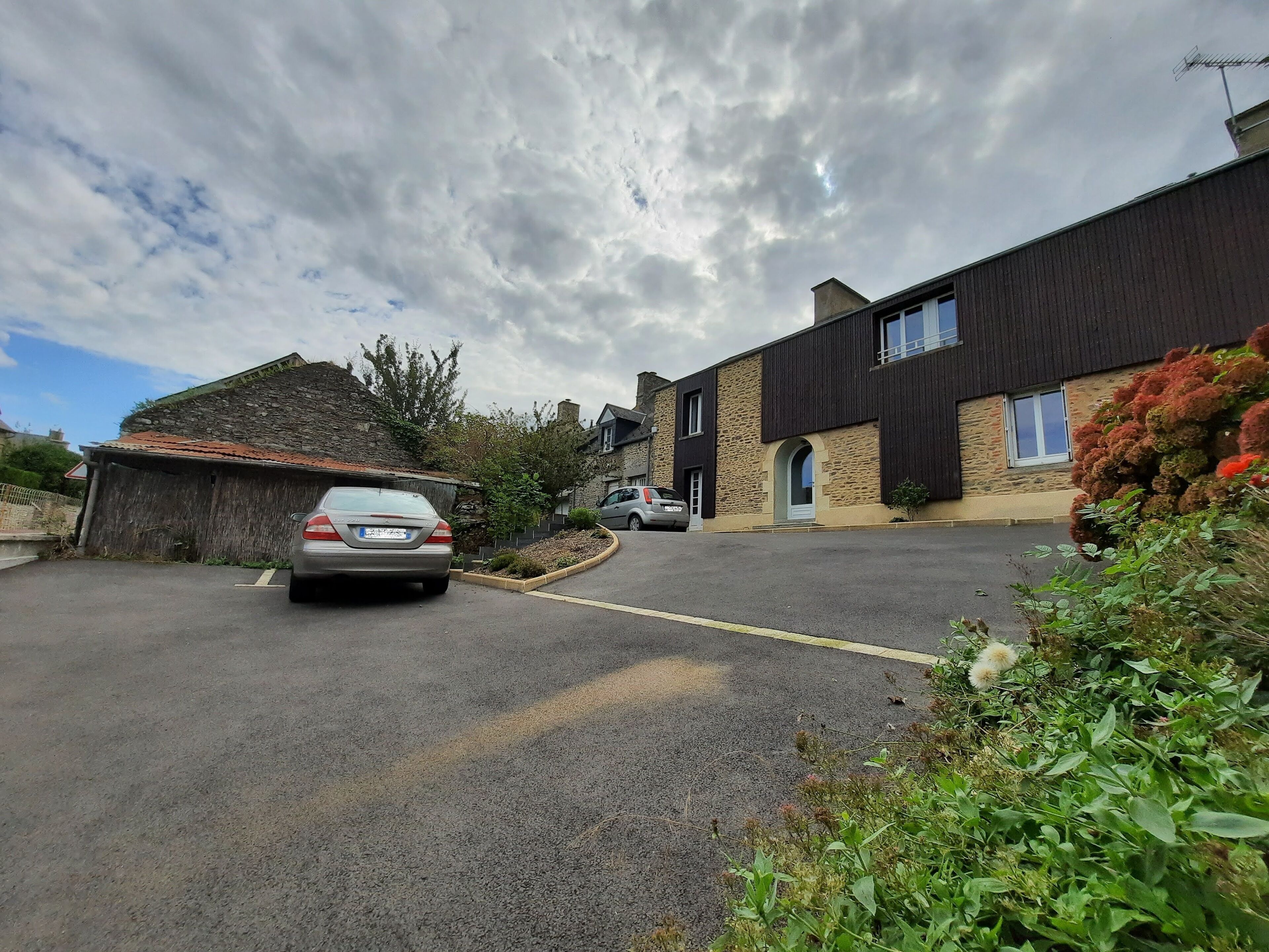 A residential street with houses, a parked car, and a clear sky.