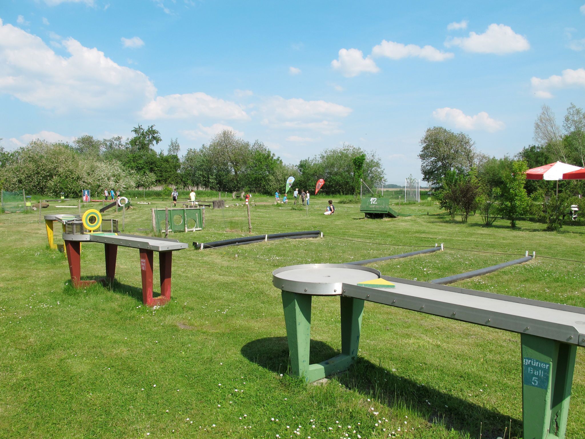 A park with green grass, playground equipment, and a picnic table.