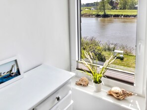 Enjoy a serene view of the lake and surrounding greenery from this room's large window.