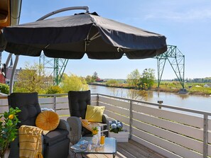 An outdoor seating area with a table, chairs, and a large umbrella. - Osteblick by Interhome (Wingst)