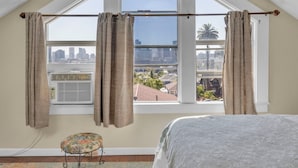Un dormitorio con un ventanal grande, una cama y un radiador.