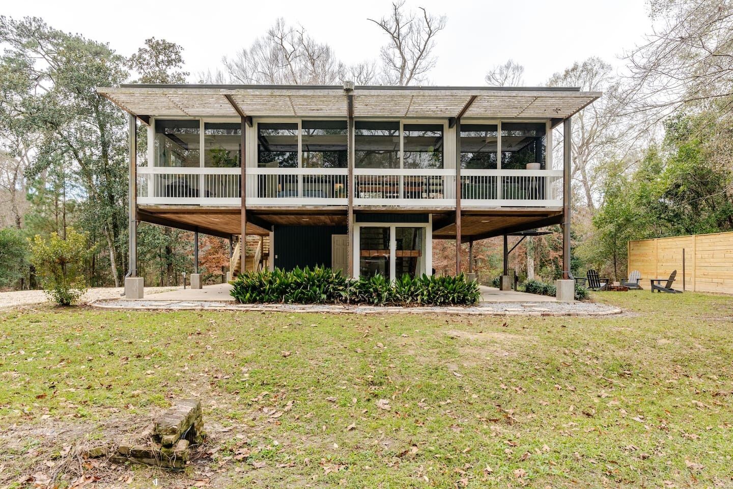 A modern two-story house with a flat roof and a balcony.