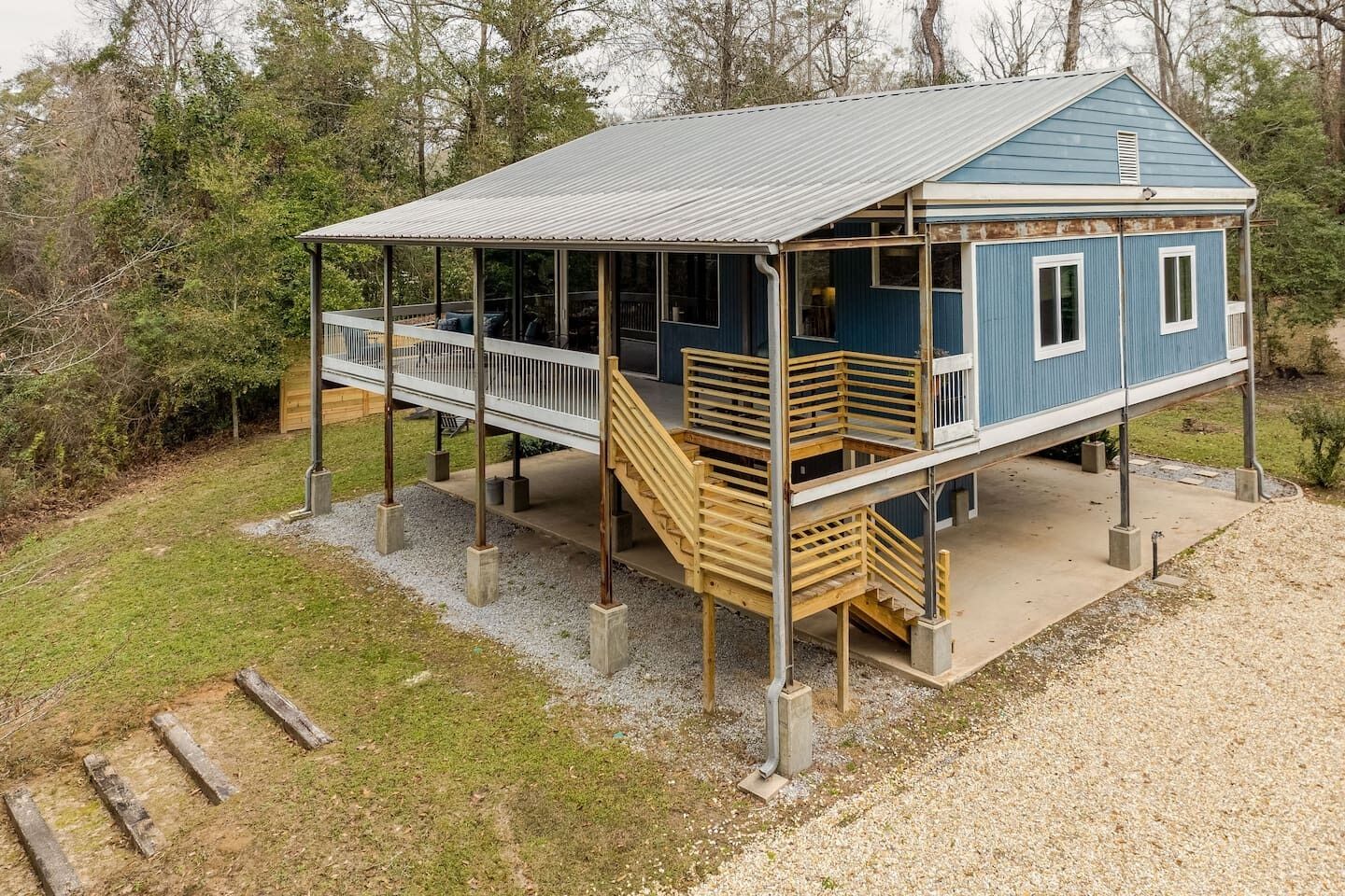 A two-story house with a covered porch, a staircase, and a deck.