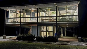 A modern two-story building with large glass windows and a flat roof.