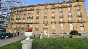 Un bâtiment historique doté de nombreux balcons et d’une entrée centrale.