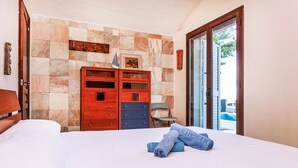 Ein Hotelzimmer mit einem Bett, einem Holzschrank und einer Steinwand.