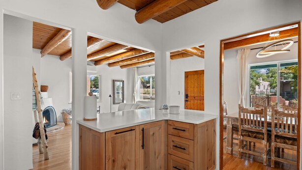 Une cuisine moderne avec des meubles en bois, un grand îlot central et un coin repas doté de meubles en bois.