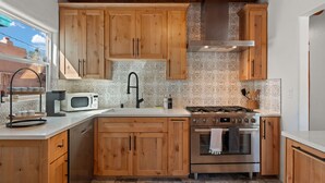 Une cuisine avec des meubles en bois, une cuisinière en acier inoxydable, un four à micro-ondes et un évier.